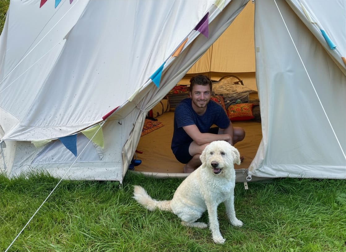 Guest sitting inside a bell tent with a white dog at Batcombe Vale Campsite