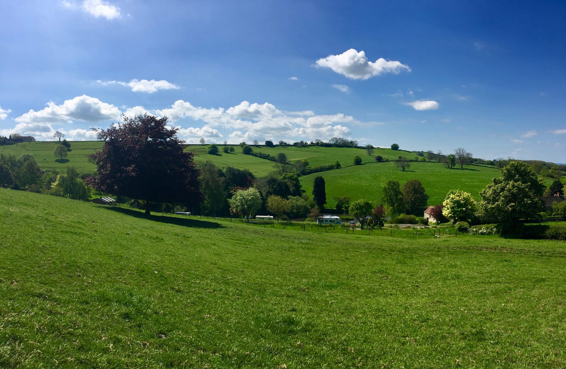 Hilltop view of Batcombe Vale adult-only campsite nestled in the Somerset valley, surrounded by rolling green hills and countryside near Bruton