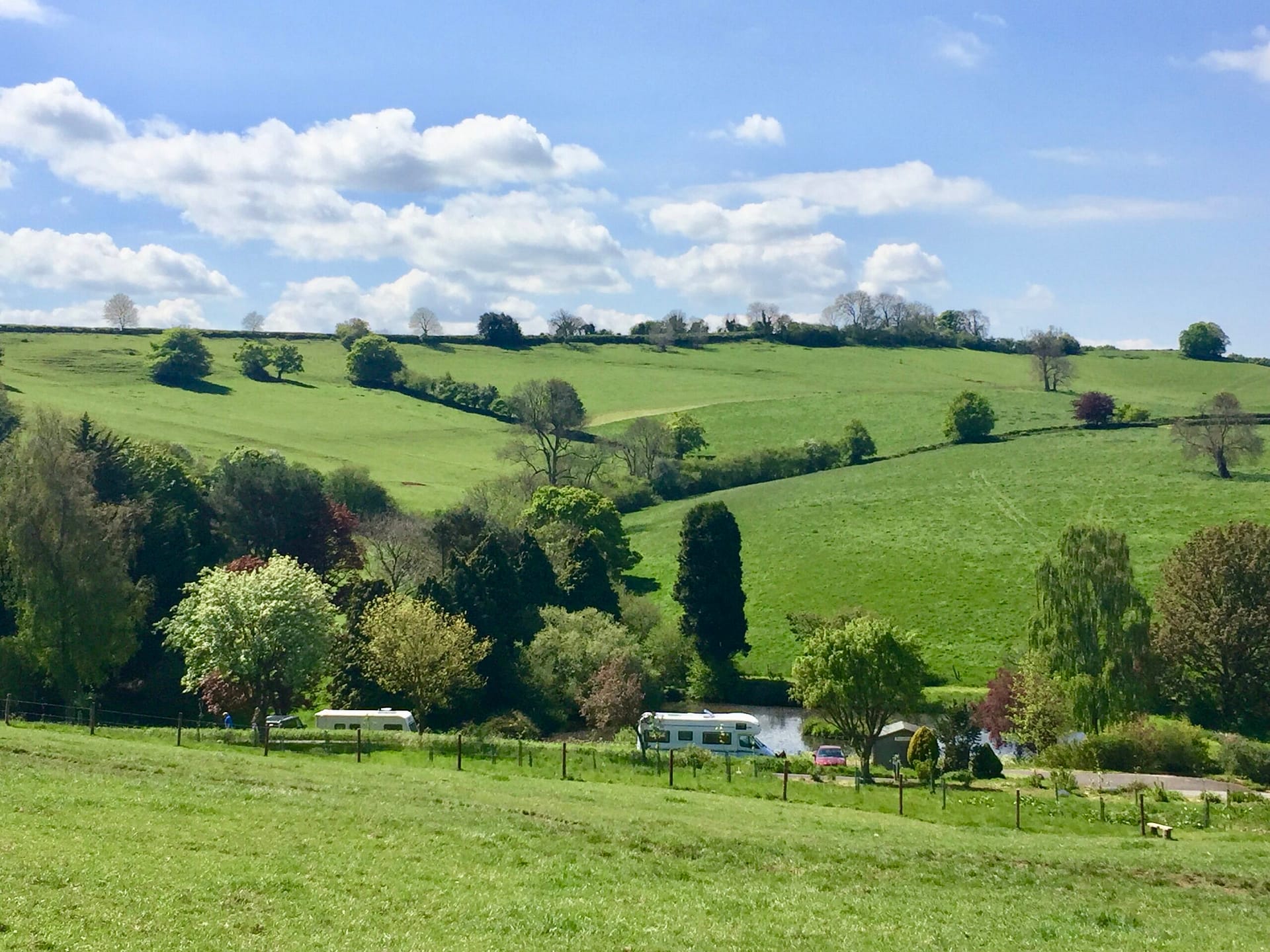 Valley view of Batcombe Vale Campsite with the lake and mature trees